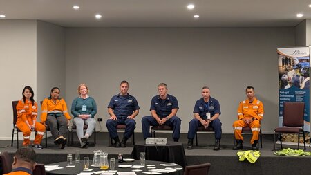 Group photo of individuals seated during a panel discussion at the Pacific Symposium of marine pollution response preparedness workshop, ITOPF representative pictured third from left in blue top and grey trousers